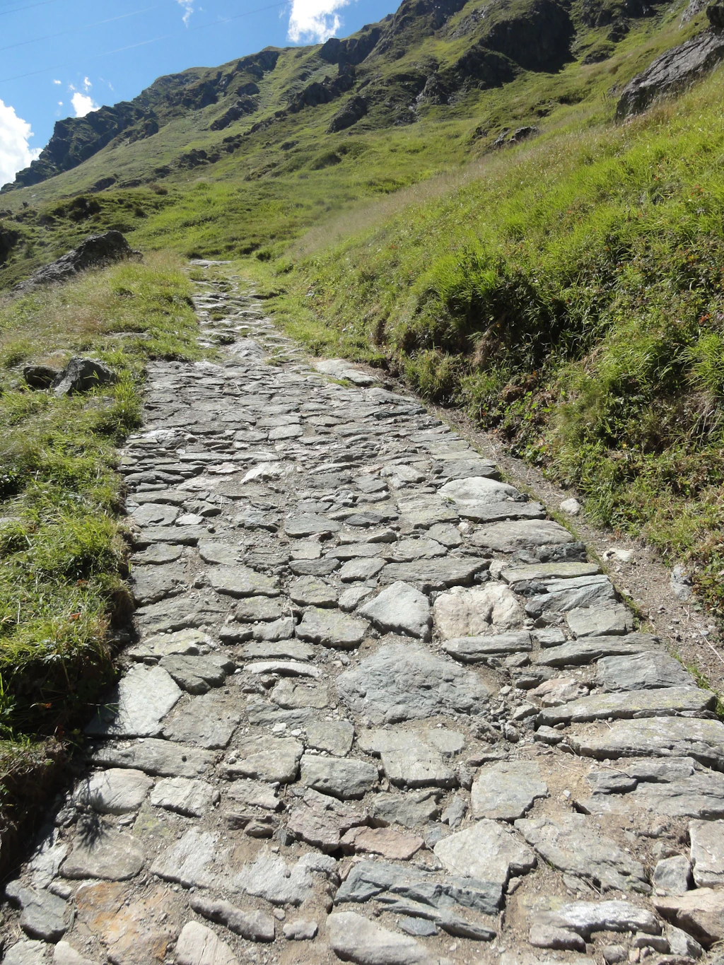 Grasbewachsene Bollensteinpflästerung am Septimerpass